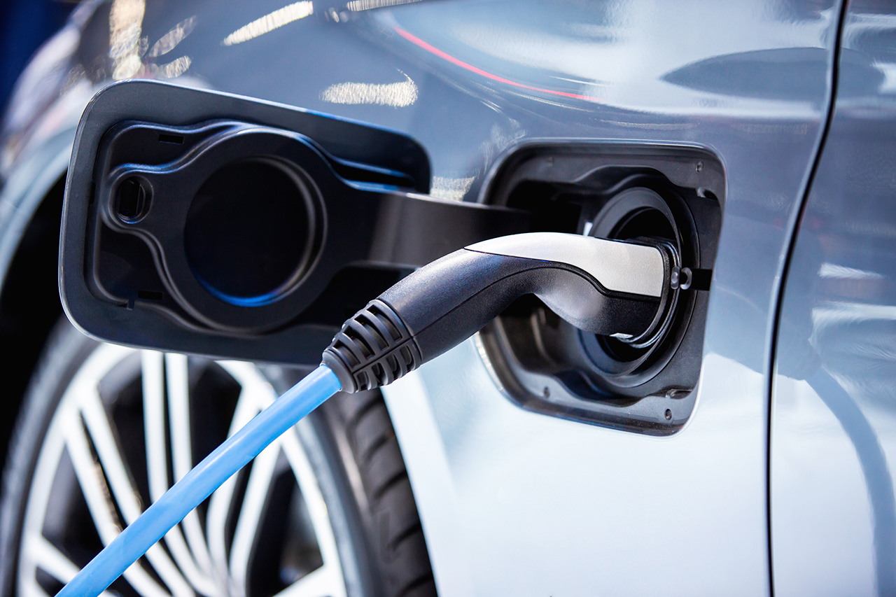 The power supply plugged into an electric car to charging a battery at the charging station, The power supply plugged into an electric car to charging a batt